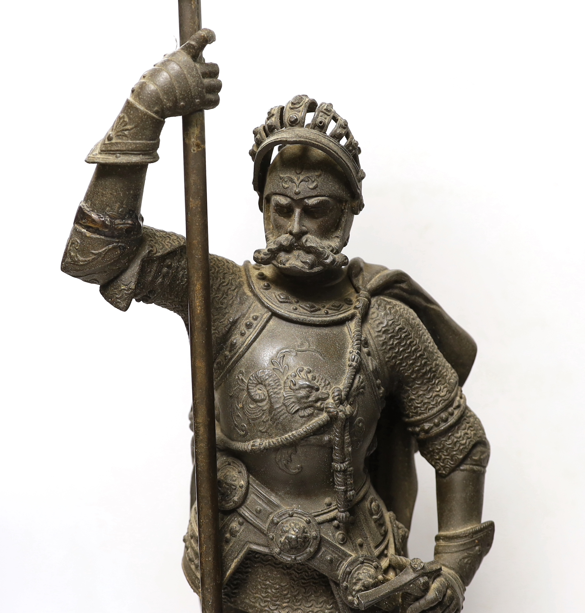 A spelter table lamp of a knight in armour carrying torch, with flame glass shade, approx 75cm high